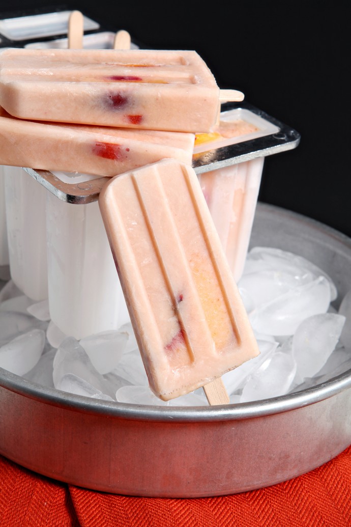 Cool down this August with slightly sweet and dreamy Peaches and Cream Popsicles! Sprinkle sliced peaches with sugar, letting them steep in the beautiful liquid. Strain the peaches and save the juices... then combine the juice with Greek yogurt and a few peaches to create these decadent popsicles!